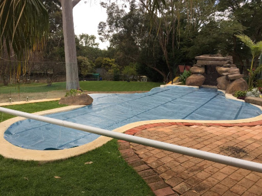  A curved, grotto pool area with a 525TB pool cover. 