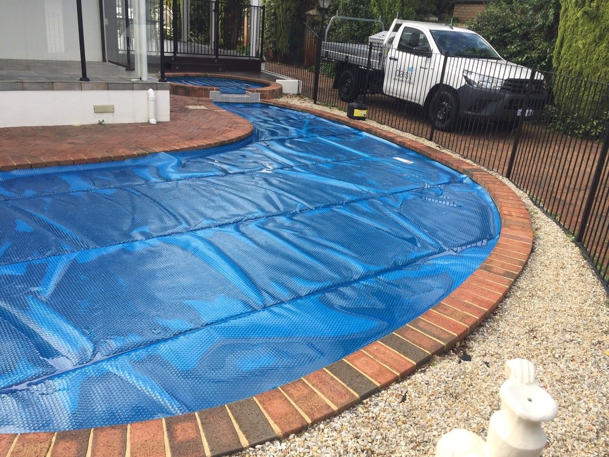  A curved swimming pool with a 525B Solar Cover and separate spa cover. 